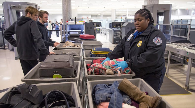 TSA agent Kimberly Black helps passengers get through security at Hartsfield-Jackson International Airport. STEVE SCHAEFER / SPECIAL TO THE AJC