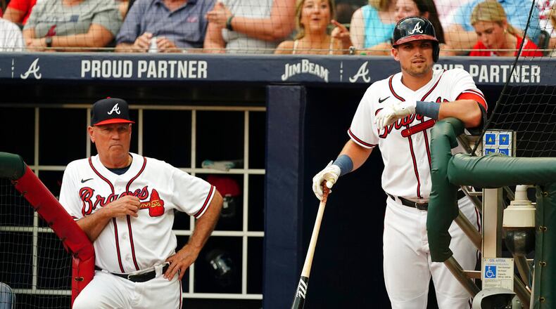 Braves manager Brian Snitker (left) and third baseman Austin Riley watch from the dugout during an August game. (AP Photo/John Bazemore)