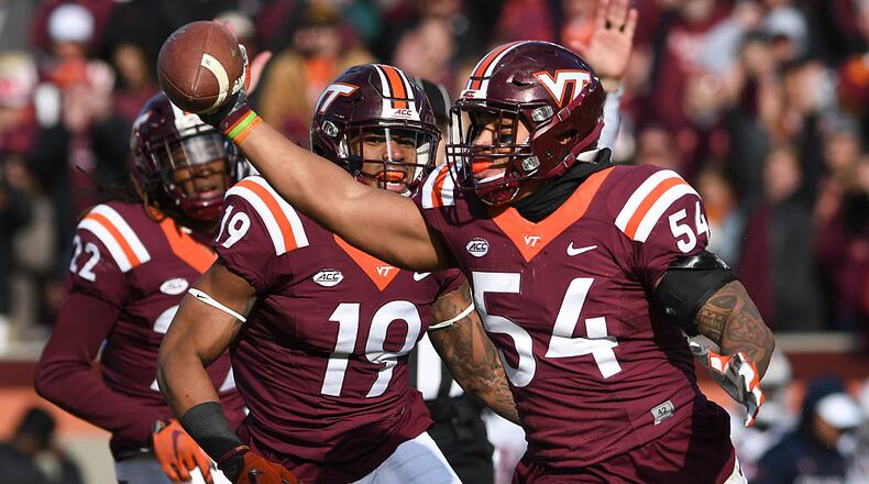 BLACKSBURG, VA - NOVEMBER 26: Linebacker Andrew Motuapuaka #54 of the Virginia Tech Hokies celebrates his interception against the Virginia Cavaliers with defensive back Chuck Clark #19 in the second half at Lane Stadium on November 26, 2016 in Blacksburg, Virginia. Virginia Tech defeated Virginia 52-10. (Photo by Michael Shroyer/Getty Images)