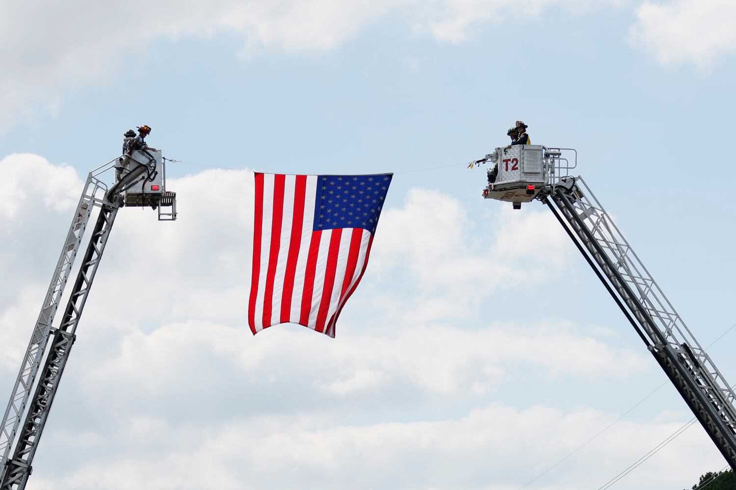 Members of the Paulding County Firefighter department salute the hearse of fallen Marshall Samual Ervin Jr as the procession passes on Dallas Highway on Wednesday, September 15, 2022. Miguel Martinez / miguel.martinezjimenez@ajc.com