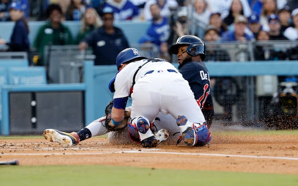 Atlanta Braves' Bryan De La Cruz, right, is tagged out by Los Angeles Dodgers catcher Will Smith at home plate during the first inning of a baseball game Wednesday, April 2, 2025, in Los Angeles. (AP Photo/Kevork Djansezian)