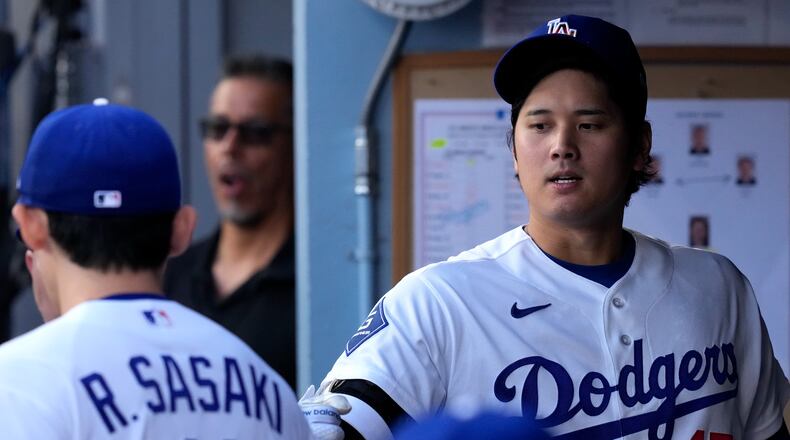 Los Angeles Dodgers starting pitcher Roki Sasaki, left, greets Shohei Ohtani I. The dugout prior to a baseball game against the Los Angeles Angels, Friday, June 5, 2026, in Los Angeles. (AP Photo/Mark J. Terrill)