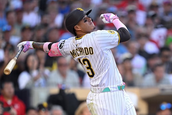 San Diego Padres' Manny Machado hits a sacrifice fly to score Fernando Tatis Jr. during the seventh inning of a baseball game against the Philadelphia Phillies, Saturday, July 12, 2025, in San Diego. (AP Photo/Orlando Ramirez)