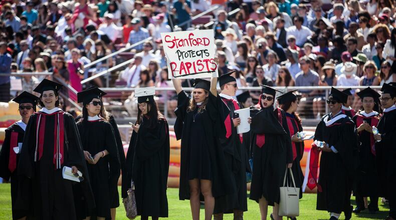 STANFORD, CA - JUNE 12: Graduating student, Andrea Lorei, who help organize campus demonstrations holds a sign in protest during the 'Wacky Walk' before the 125th Stanford University commencement ceremony on June 12, 2016 in Stanford, California. The university holds its commencement ceremony amid an on-campus rape case and its controversial sentencing. (Photo by Ramin Talaie/Getty Images)