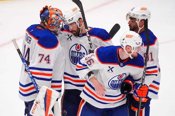 Edmonton Oilers goaltender Stuart Skinner (74) gathers with teammates, from left defenseman Evan Bouchard, defenseman John Klingberg (36) and left wing Evander Kane (91) following a 3-0 win over the Dallas Stars in Game 2 of the Western Conference finals in the NHL hockey Stanley Cup playoffs, Friday, May 23, 2025, in Dallas. (AP Photo/LM Otero)