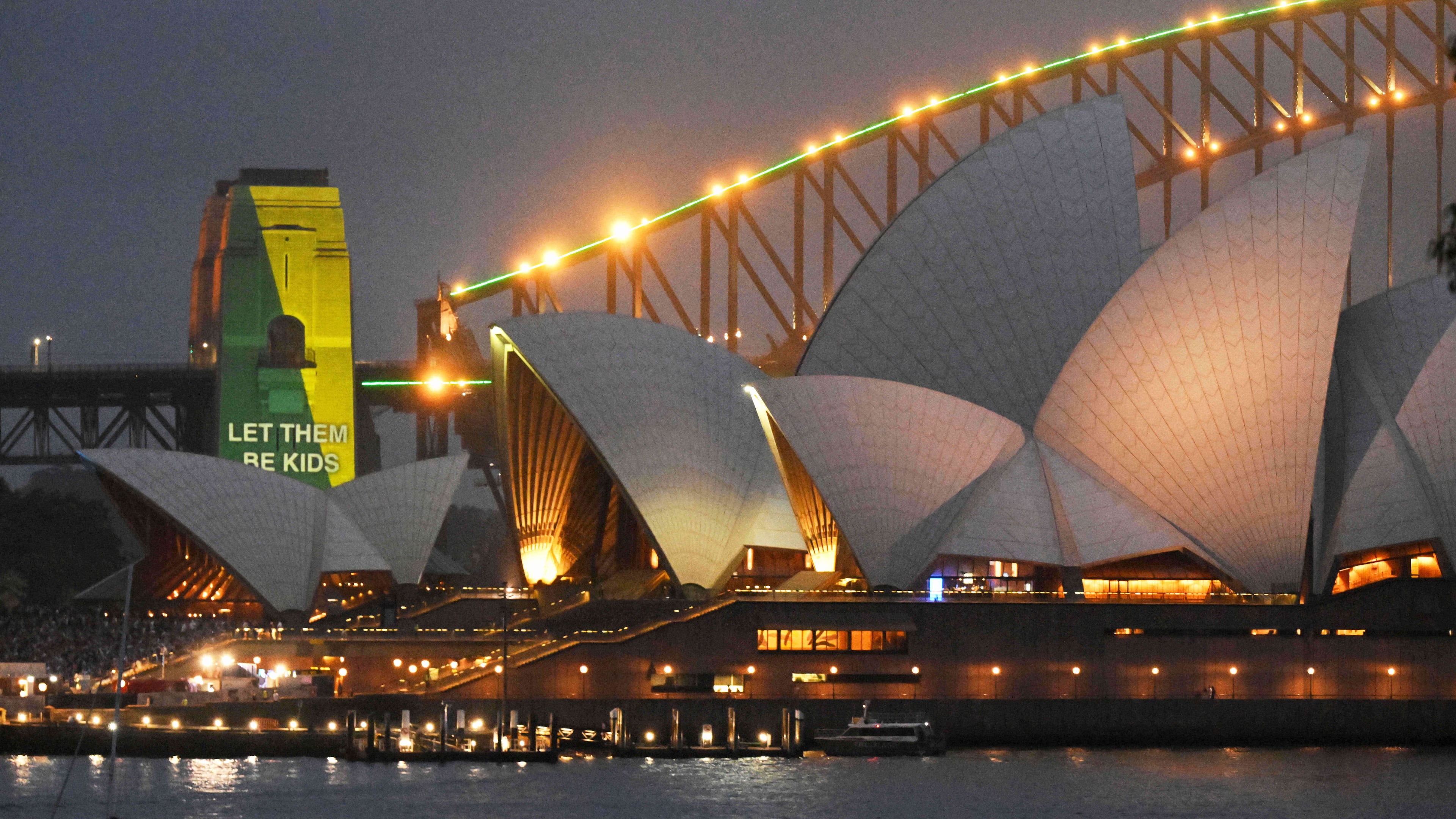 The social media ban for children under 16 slogan "Let Them Be Kids" is projected onto the pylons of the Sydney Harbour Bridge in Sydney, Wednesday, Dec. 10, 2025. (Mick Tsikas/AAP Image via AP)