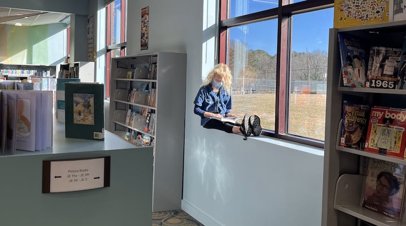 A child has a bird's-eye seat reading a book at the main branch of the Athens-Clarke County Library. (Courtesy of Molly Pratt)