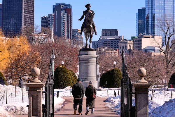 Ahead of Presidents Day, a couple walked toward a statue of George Washington in Boston. (Charles Krupa/AP)