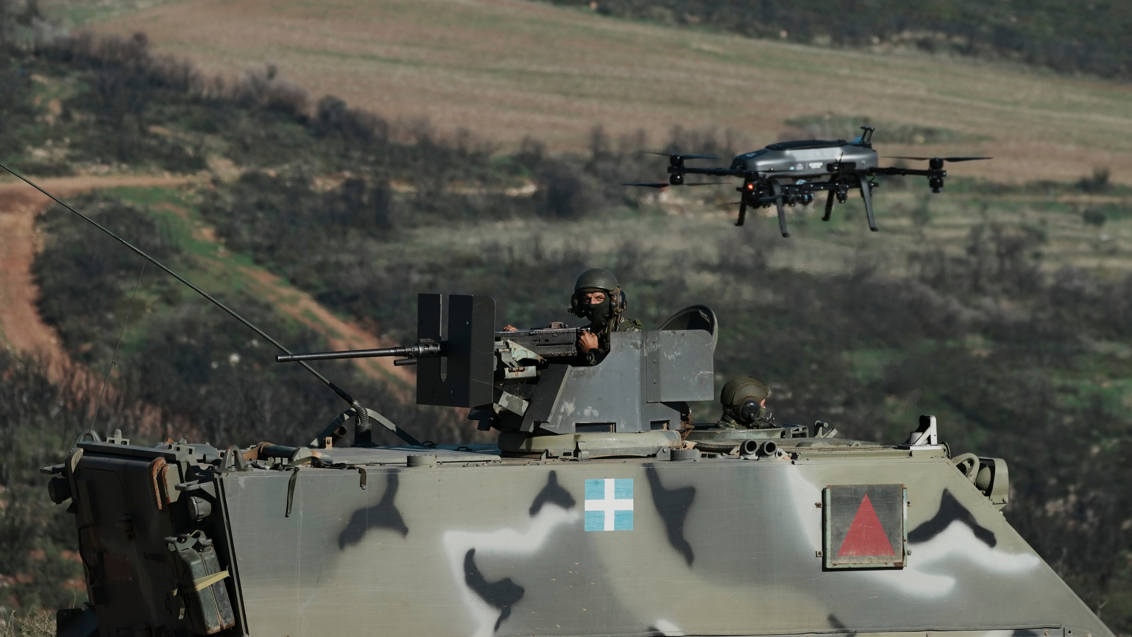 A drone flies above a Greek army armored vehicle in a live-fire exercise near the northeastern city of Alexandroupolis, Greece, testing domestically-developed drones and counter-drone systems as part of NATO's modernization efforts on Friday, Nov. 14, 2025. (AP Photo/Thanassis Stavrakis)