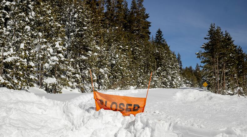 FILE - A closed sign is partially buried at the entrance to the Castle Peak trailhead in Soda Springs, Calif., Friday, Feb. 20, 2026. (Stephen Lam/San Francisco Chronicle via AP, File)