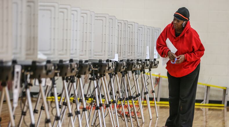 Poll worker Cathy Gray prepares the machines for voting. Voters lined up early at Henry W. Grady High School in Atlanta on Tuesday, Nov. 7, 2017 to cast their votes. JOHN SPINK/JSPINK@AJC.COM