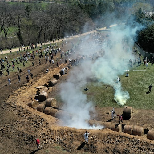 Animal rights activists react to tear gas while attempting to gain entry into Ridglan Farms beagle breeding and research facility in Blue Mounds, Wis., Saturday, April 18, 2026. (Amber Arnold/Wisconsin State Journal via AP)