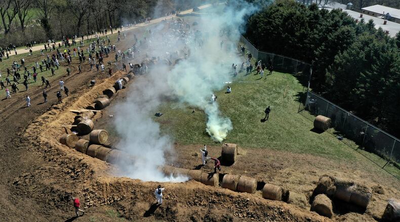 Animal rights activists react to tear gas while attempting to gain entry into Ridglan Farms beagle breeding and research facility in Blue Mounds, Wis., Saturday, April 18, 2026. (Amber Arnold/Wisconsin State Journal via AP)