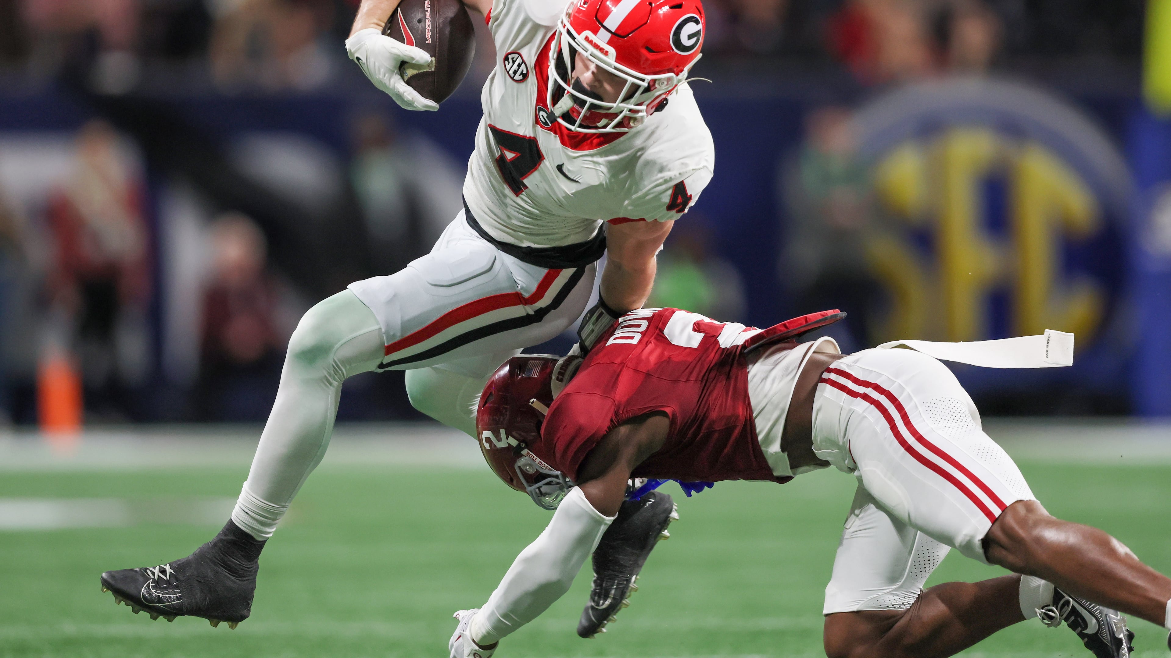 Georgia Bulldogs tight end Oscar Delp (4) is stopped by Alabama Crimson Tide defensive back Caleb Downs (2) during the first half of the SEC Championship football game at the Mercedes-Benz Stadium in Atlanta, on Saturday, December 2, 2023. (Jason Getz / Jason.Getz@ajc.com)
