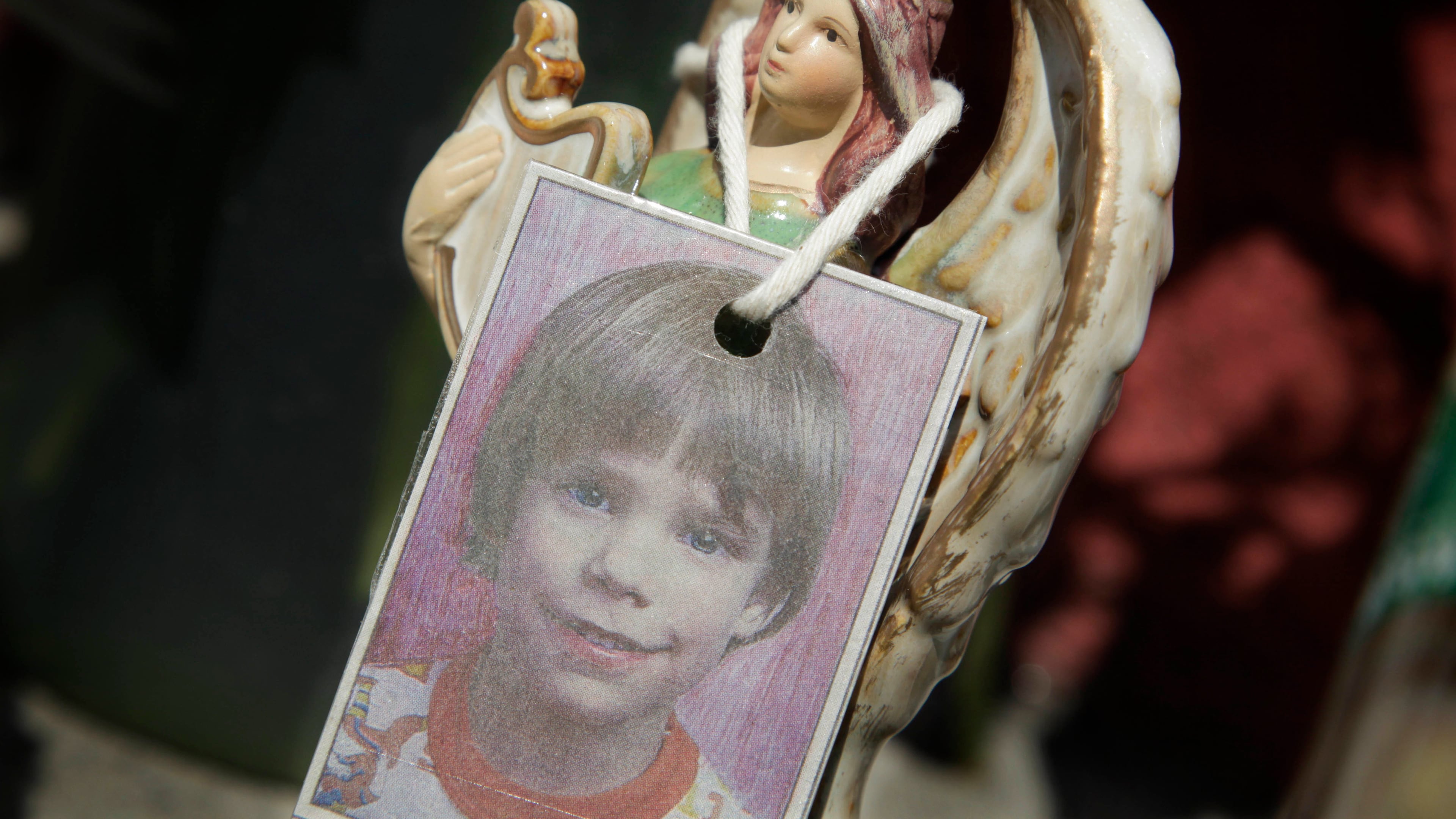 FILE - A photograph of Etan Patz hangs on an angel figurine, as part of a makeshift memorial in the SoHo neighborhood of New York, May 28, 2012. (AP Photo/Mark Lennihan, File)