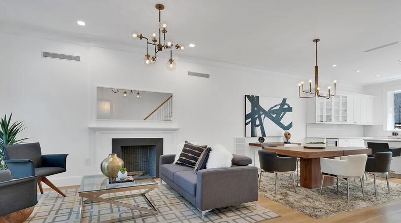 Two similar yet different brass industrial chandeliers complement a combined dining/living room area. (H5 Property)