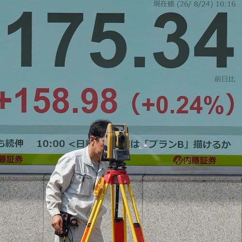 A surveyor works in front of a stock market chart Monday, Aug. 24, 2026 in Tokyo. (AP Photo/Eugene Hoshiko)