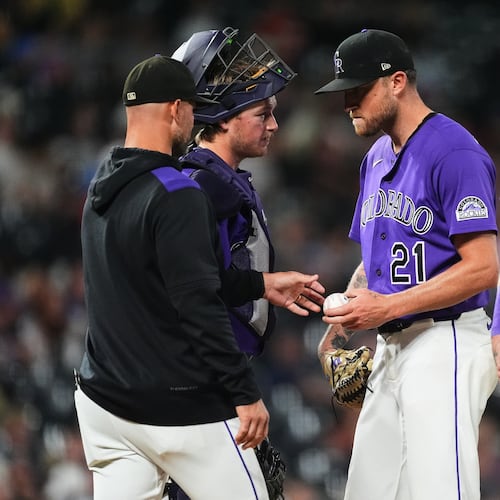Colorado Rockies starting pitcher Kyle Freeland, center, hands the ball as he is pulled from the mound to manager Warren Schaeffer, front left, as catcher Hunter Goodman, back left, and first baseman TJ Rumfield look on in the fourth inning of a baseball game against the Arizona Diamondbacks Tuesday, Sept. 22, 2026, in Denver. (AP Photo/David Zalubowski)