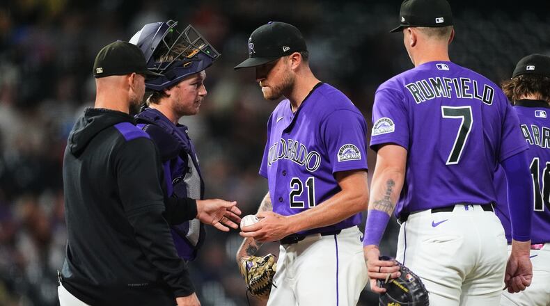 Colorado Rockies starting pitcher Kyle Freeland, center, hands the ball as he is pulled from the mound to manager Warren Schaeffer, front left, as catcher Hunter Goodman, back left, and first baseman TJ Rumfield look on in the fourth inning of a baseball game against the Arizona Diamondbacks Tuesday, Sept. 22, 2026, in Denver. (AP Photo/David Zalubowski)