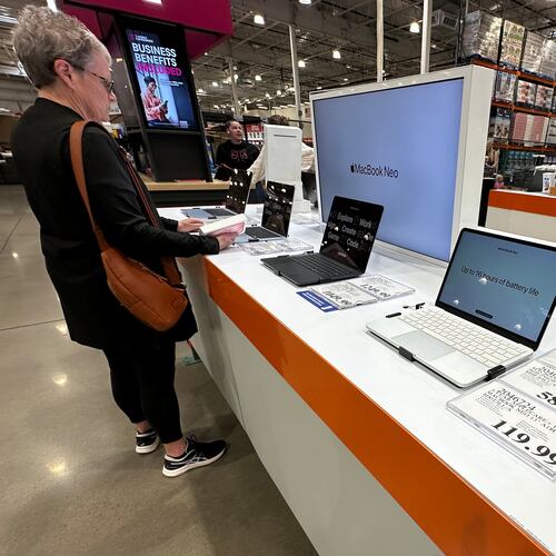 FILE - A shopper looks over Apple MacBook laptops on display in a Costco warehouse on June 2, 2026, in Sheridan, Colo. (AP Photo/David Zalubowski, File)
