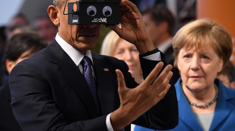 HANOVER, GERMANY - APRIL 25: U.S. President Barack Obama and German Chancellor Angela Merkel test virtual reality glasses at the ifm electronics stand at the Hannover Messe industrial trade fair on April 25, 2016 in Hanover, Germany. This is likely Obama's last trip to Germany as U.S. president. The Hannover Messe is the world's largest industrial trade fair. (Photo by Alexander Koerner/Getty Images)