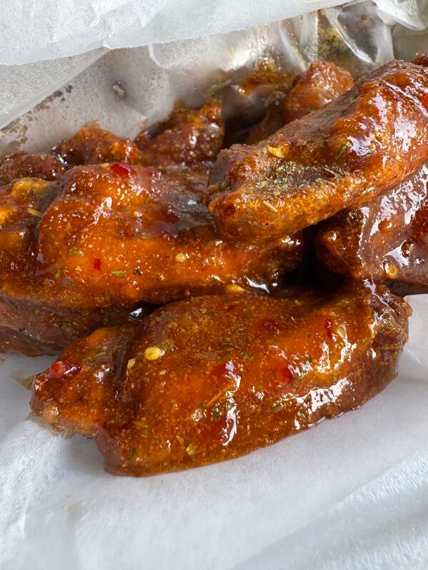 Heavily sauced hot wings in a takeout box