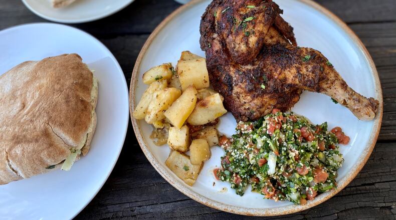 Takeout from Aviva by Kameel in Midtown: Rosemary chicken with roasted potatoes and tabouleh. Left, a pita pocket with falafel and all the fixings (hummus, baba ghanoush, cabbage salad, Nazareth salad). In the back: Pita, baba ghanoush and mujadara.
Wendell Brock for The Atlanta Journal-Constitution