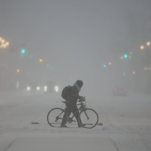 A person pushed a bicycle during a winter storm in Philadelphia, Sunday, Jan. 25, 2026. (AP Photo/Matt Rourke)