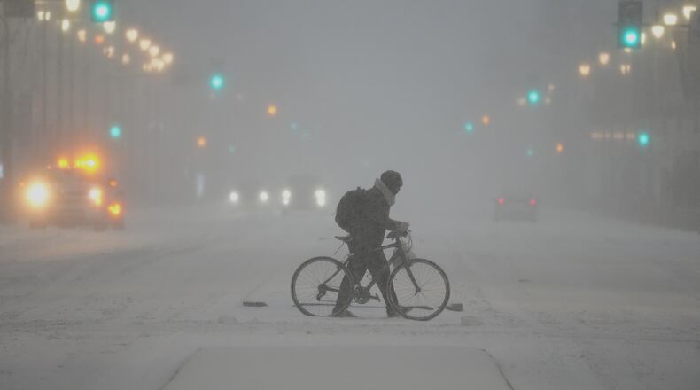 A person pushed a bicycle during a winter storm in Philadelphia, Sunday, Jan. 25, 2026. (AP Photo/Matt Rourke)