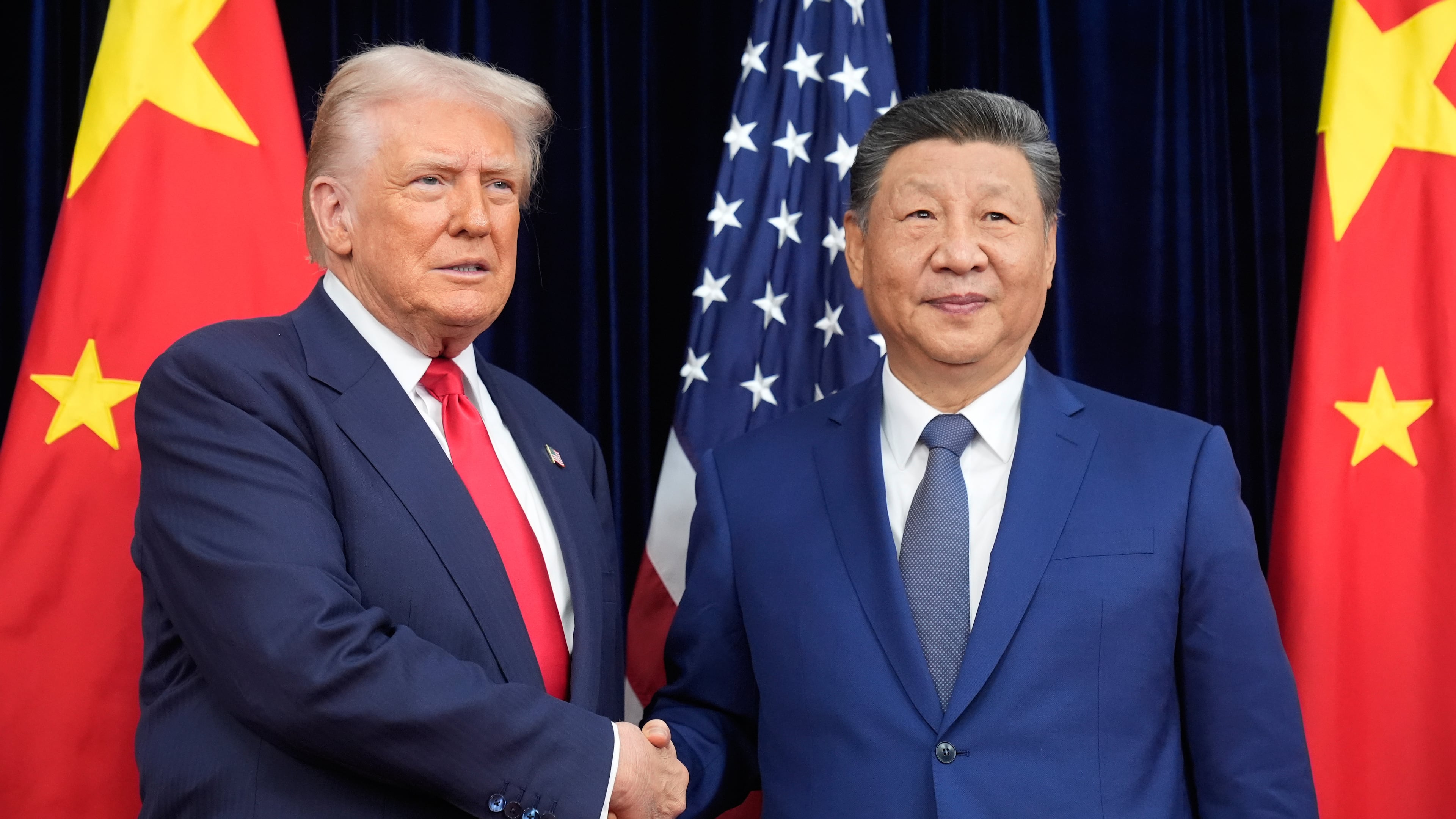 President Donald Trump, left, and Chinese President Xi Jinping shake hands before their meeting at Gimhae International Airport in Busan, South Korea, Thursday, Oct. 30, 2025. (AP Photo/Mark Schiefelbein)