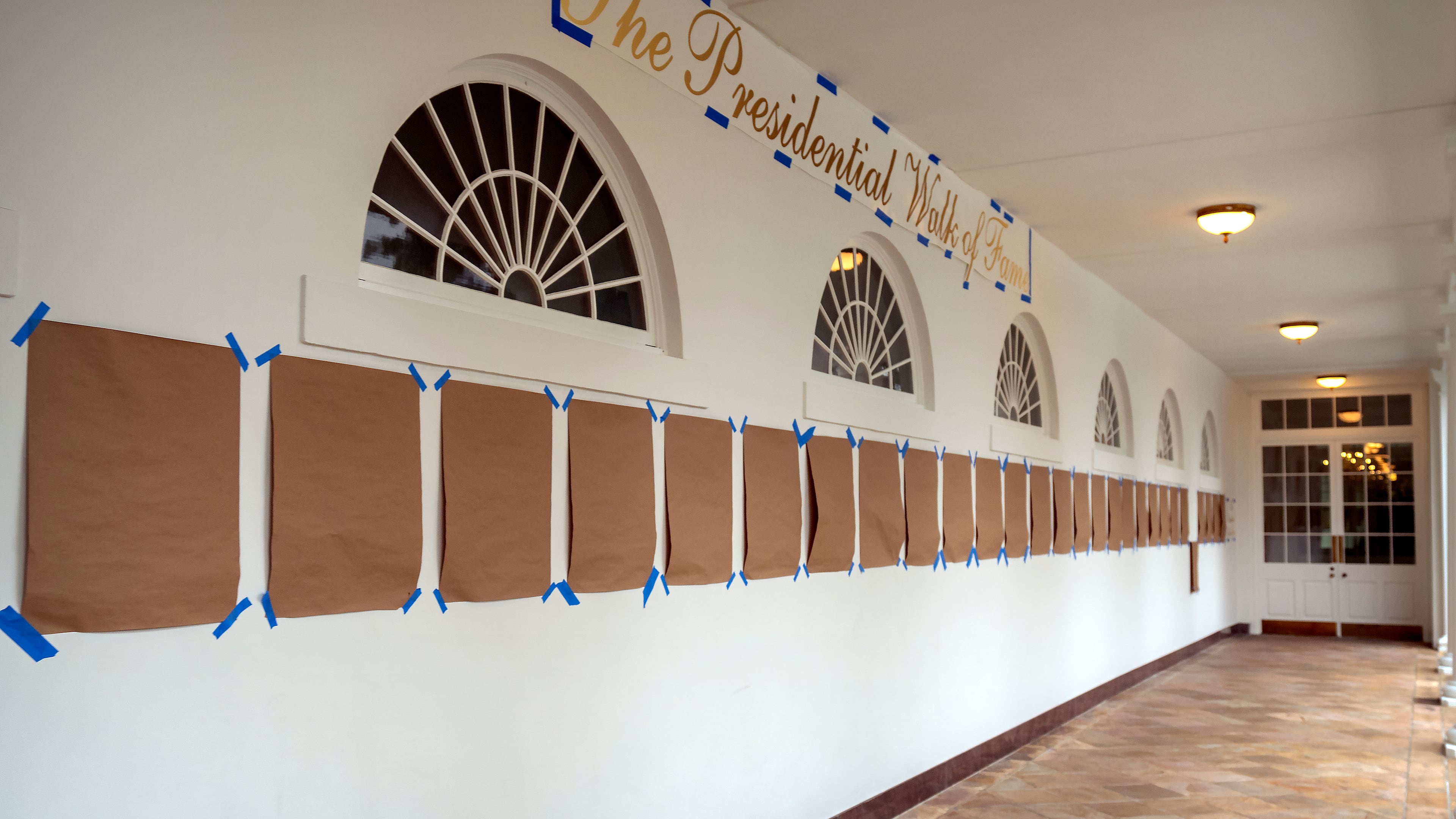 A sign reading "The Presidential Walk of Fame" and pieces of brown paper are taped along the wall of the White House colonnade next to the Rose Garden, Sunday, Sept. 21, 2025, in Washington. (AP Photo/Mark Schiefelbein)