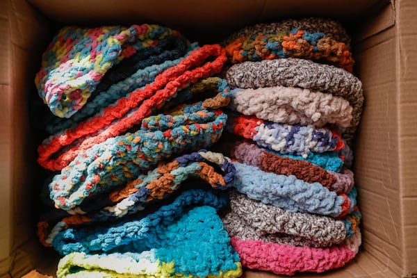 A box of colorful crocheted hats are ready for donation to cancer patients. (Natrice Miller/AJC)