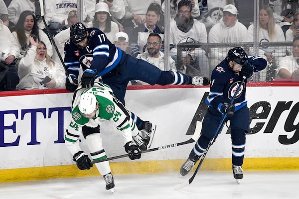 Winnipeg Jets' Adam Lowry (17) and Neal Pionk (4) collide with Dallas Stars' Roope Hintz (24) during first period NHL playoff hockey action in Winnipeg, Wednesday, May 7, 2025. (Fred Greenslade/The Canadian Press via AP)