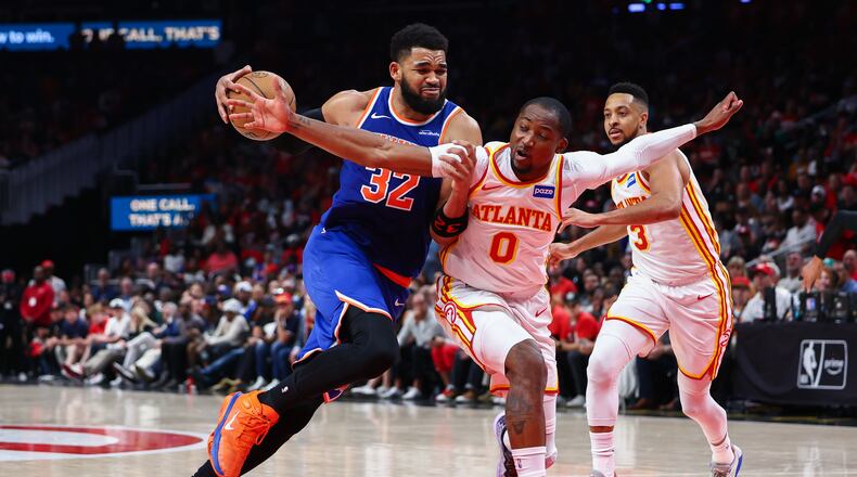 New York Knicks center Karl-Anthony Towns (32) drives to the basket against Atlanta Hawks forward Jonathan Kuminga (0) during the second half in Game 3 of a first-round NBA playoffs basketball series, Thursday, April 23, 2026, in Atlanta. (AP Photo/Colin Hubbard)