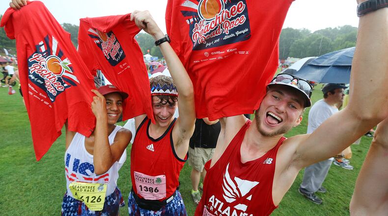 070415 ATLANTA: Max Rabin (from left), Adam Burkley and Hayden Cox, from Johns Creek, celebrate with their t-shirts in Piedmont Park after finishing the AJC Peachtree Road Race on Saturday, July 4, 2015, in Atlanta. Curtis Compton / ccompton@ajc.com