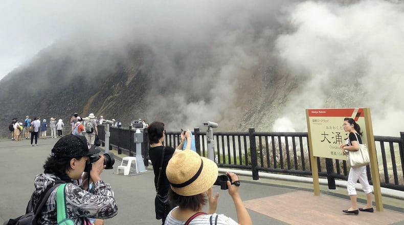 Visitors to Owakudani Park in Hakone, Japan, stop for photos against the background of volcanic plumes. Japan News-Yomiuri photo