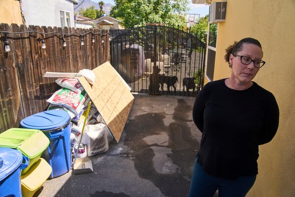 Eaton fire survivor Dr. Nicole Maccalla, a data scientist and a lead investigator, checks the exterior repairs made to her smoke damaged home in Altadena, Calif., on Friday, April 4, 2025. (AP Photo/Damian Dovarganes)
