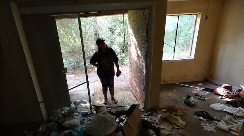 Decatur: Kristy Neff looks into an apartment in her unit where the windows are all broken out and trash litters the floor in The Village at Kensington on Sept. 6, 2022, in Decatur. “Curtis Compton / Curtis Compton@ajc.com