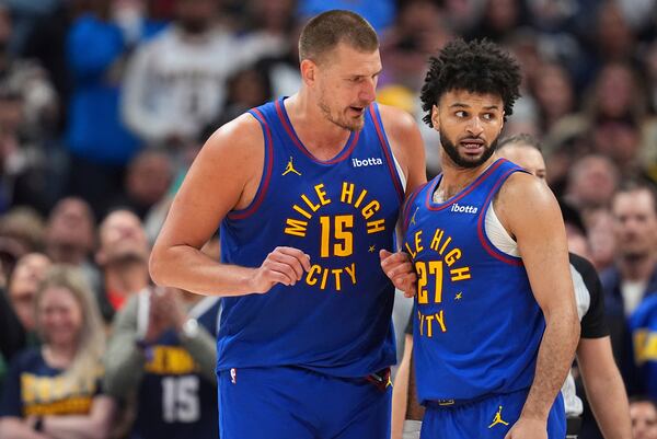 Denver Nuggets center Nikola Jokic, left, confers with guard Jamal Murray, right, in the second half of Game 1 of an NBA first-round playoff series against the Los Angeles Clippers, Saturday, April 19, 2025, in Denver. (AP Photo/David Zalubowski)