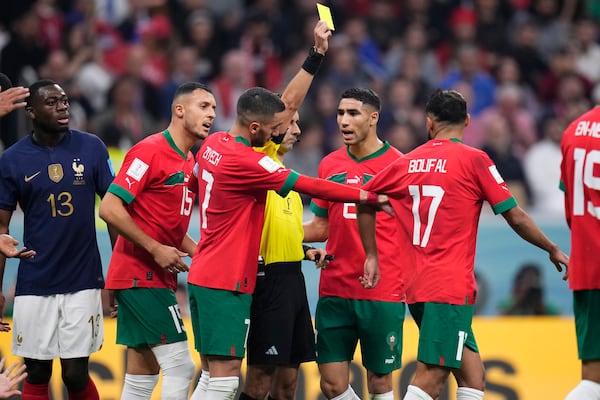 Referee Cesar Ramos, of Mexico, shows a yellow card to Morocco's Sofiane Boufal during the World Cup semifinal soccer match between France and Morocco at the Al Bayt Stadium in Al Khor, Qatar, Wednesday, Dec. 14, 2022. (Manu Fernandez/AP)