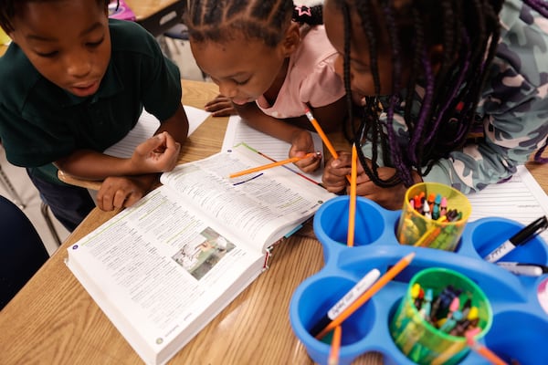 Third grade students in Taj Cole’s class look up words in dictionaries at Hollis Innovation Academy in Atlanta on Thursday, Aug. 14, 2025. The school saw a significant increase in reading scores after adding a state-funded literacy coach last year. (Natrice Miller/AJC)