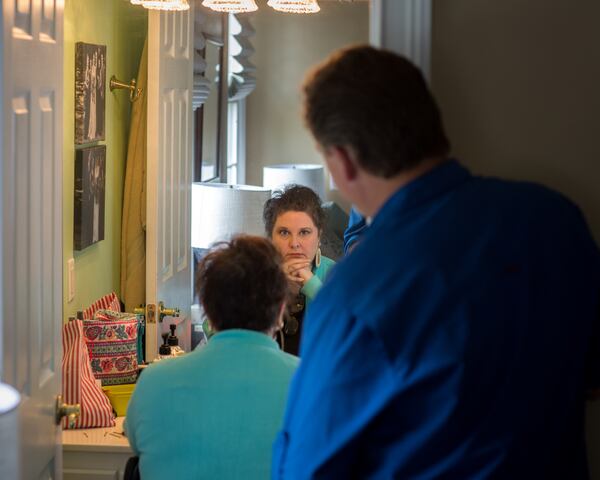 BLACKSHEAR, GA - MARCH 25, 2021: For Lisa Martin, coming to terms with her illness and its effects is made easier with the love of her devoted husband, Jeff. He compliments Lisa’s natural hair as she changes wigs in the bathroom of their home. (AJC Photo/Stephen B. Morton)