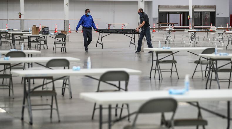 November 13, 2020 Stonecrest: DeKalb County’s John Matelski (left) and Kevin Buford (right) set up tables before a walkthrough by officials Friday, Nov. 13, 2020 of the vote counting facility at the former Sam’s Club in Stonecrest, where it plans to start its part of the recount at 7 a.m. Saturday. Officials said the facility which was used as an early voting site for the election provides more space and allows for better social distancing than would be possible at the county’s elections office off Memorial Drive. Joe Biden led Donald Trump by 14,000 votes as of Friday morning. The cost of Georgia recount six-day recount isn’t known, but initial estimates from DeKalb County indicate it might be pricey. DeKalb officials said Friday the recount will cost about $180,000, including $147,000 in pay, $20,000 for food and beverages, and $12,000 for personal protective equipment and other coronavirus-related precautions. The numbers are preliminary and may change, according to DeKalb. (John Spink / John.Spink@ajc.com)