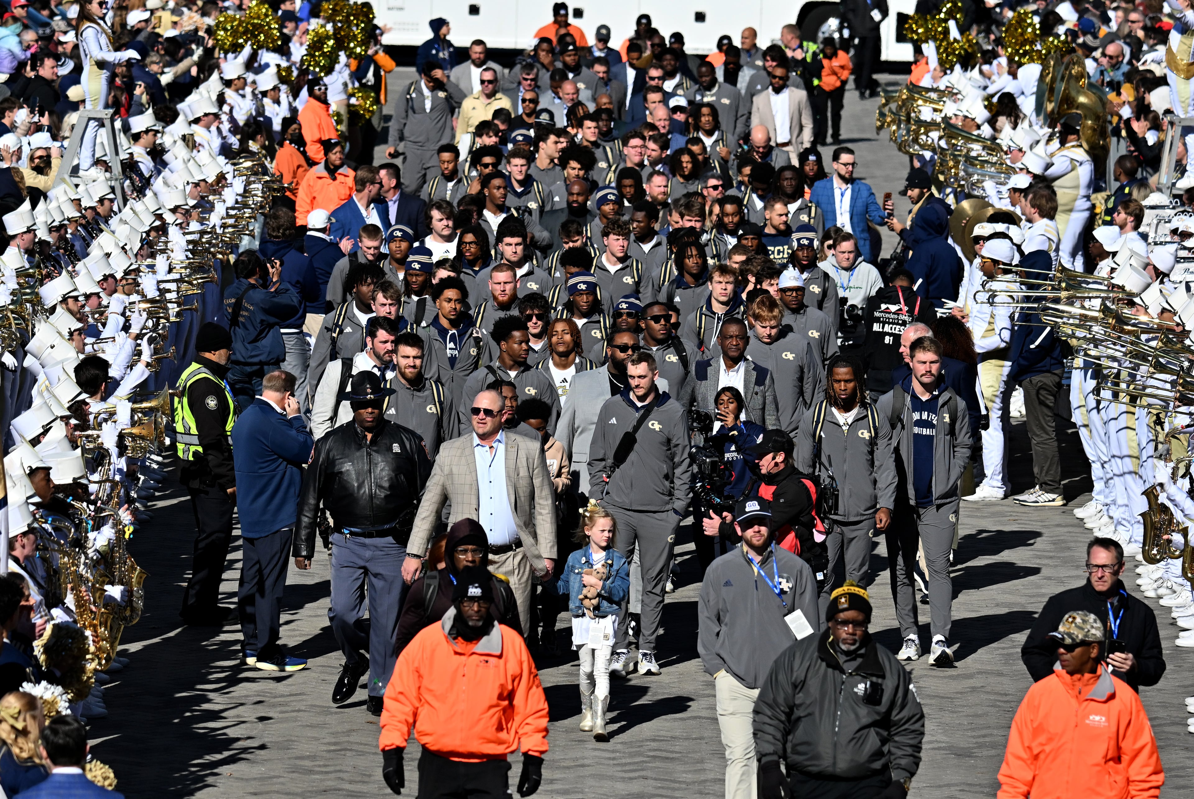Georgia Tech head coach Brent Key with his daughter Harper and players arrive before the start of the Georgia Tech vs Georgia football game at Mercedes-Benz Stadium, Friday, Nov. 28, 2025 in Atlanta. (Hyosub Shin/AJC)