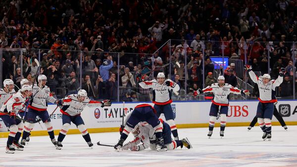 Washington Capitals left wing Alex Ovechkin (8), lower center, is celebrates with is teammates after scoring against New York Islanders during the second period of an NHL hockey game in Elmont, N.Y., Sunday, April 6, 2025. (AP Photo/Adam Hunger)