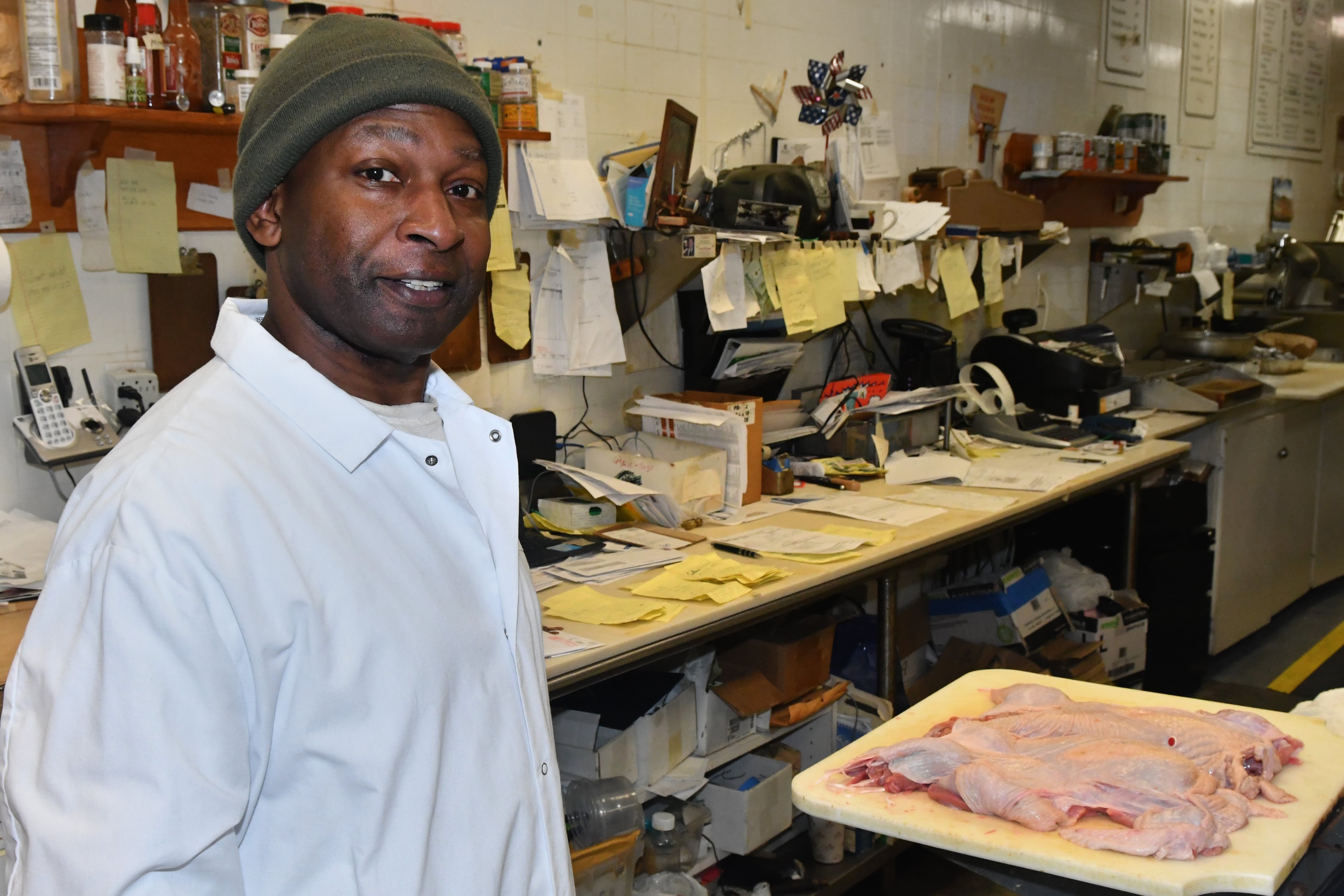 231120 Atlanta, Ga: Diamond Mardell, owner and operator of ShieldÕs Meat Market poses in his work area. Mardell says every one of those yellow slips of paper on the table behind him is an order. Mardell is a sole operator on all but his busiest days of the year, Mardell says, ÒitÕs a lot of work, but itÕs OK - because I know I can do the work of 3 peopleÓ. Photo for use in AJC Made In Georgia column by CW Cameron. The AJC visits ShieldÕs Meat Market, a seventy-six year old business started in downtown Decatur and now operating in the Emory Village business district, 1544 N.Decatur Road, Suite B, Atlanta, Ga. 30307. Owner and proprietor Diamond Mardell will be the guide for the tour. (CHRIS HUNT FOR THE ATLANTA JOURNAL-CONSTITUTION)