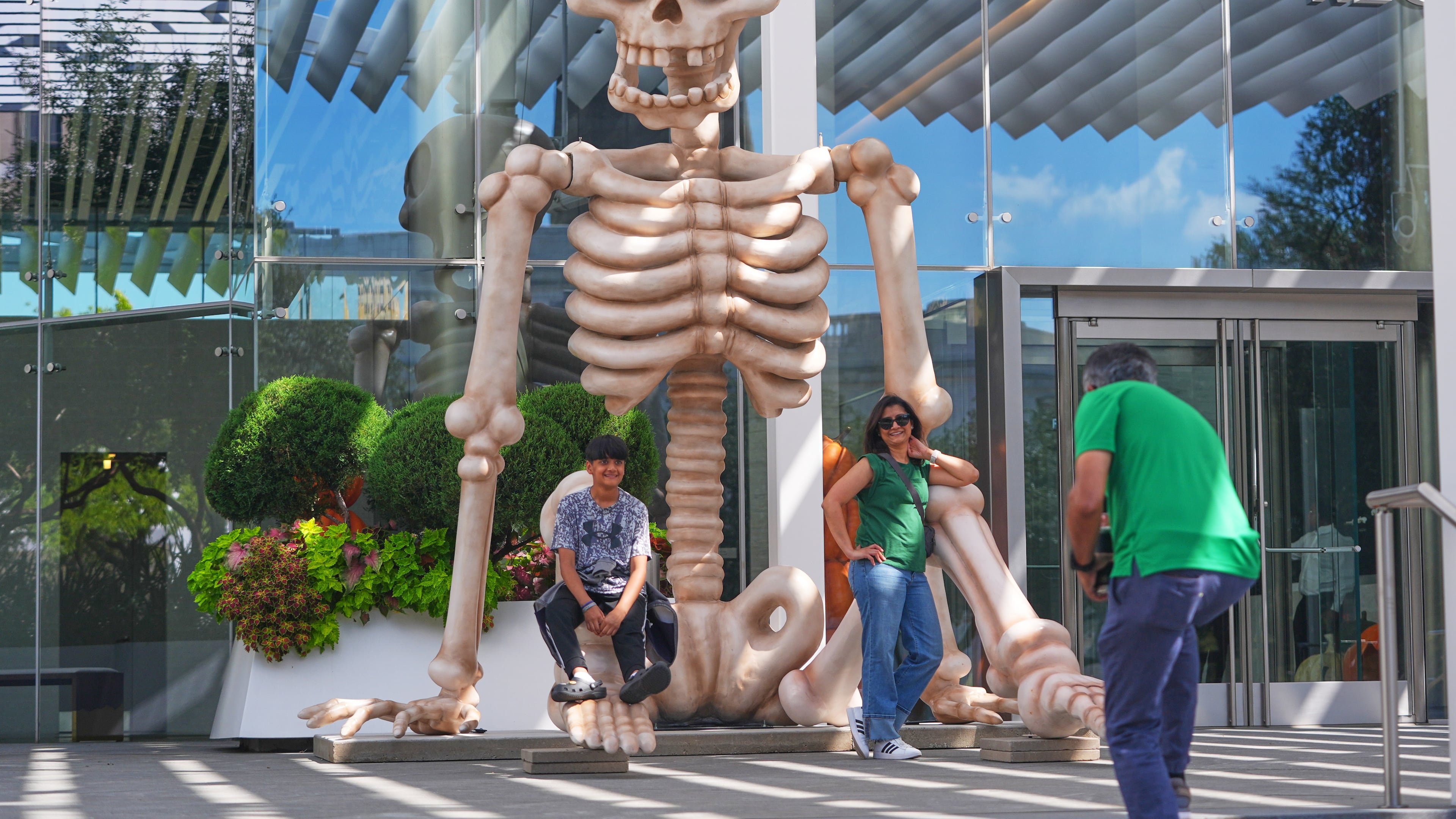 FILE _ Sam Desai, right, takes a Halloween-themed photo of his wife, Sonia Desai, and son, Rishan Desai, in downtown Dallas, Sept. 27, 2025. (AP Photo/LM Otero, File)