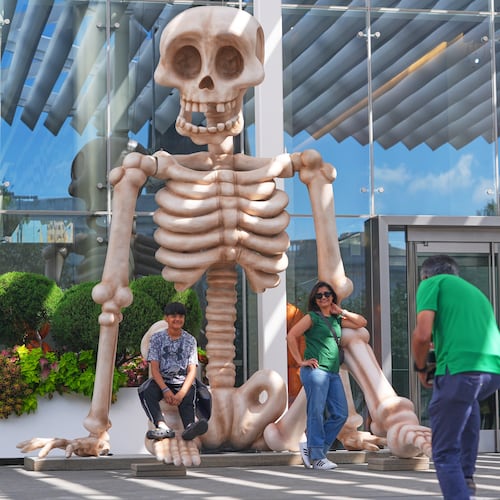 FILE _ Sam Desai, right, takes a Halloween-themed photo of his wife, Sonia Desai, and son, Rishan Desai, in downtown Dallas, Sept. 27, 2025. (AP Photo/LM Otero, File)