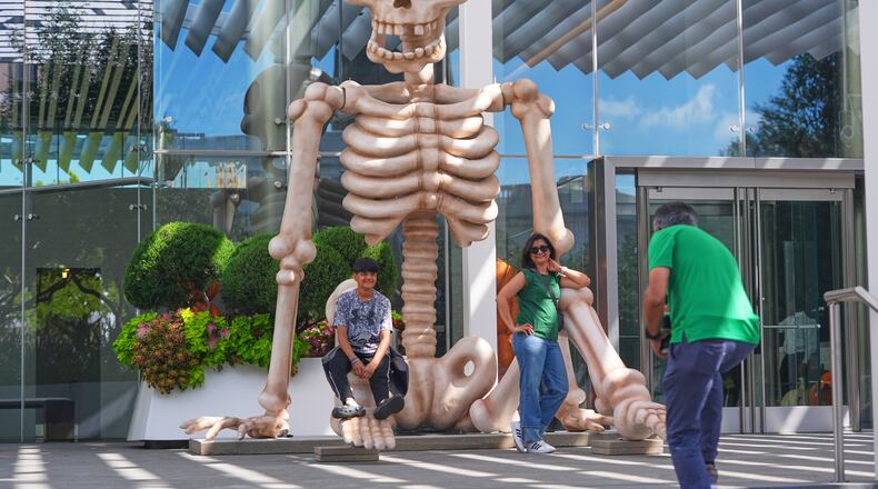 FILE _ Sam Desai, right, takes a Halloween-themed photo of his wife, Sonia Desai, and son, Rishan Desai, in downtown Dallas, Sept. 27, 2025. (AP Photo/LM Otero, File)