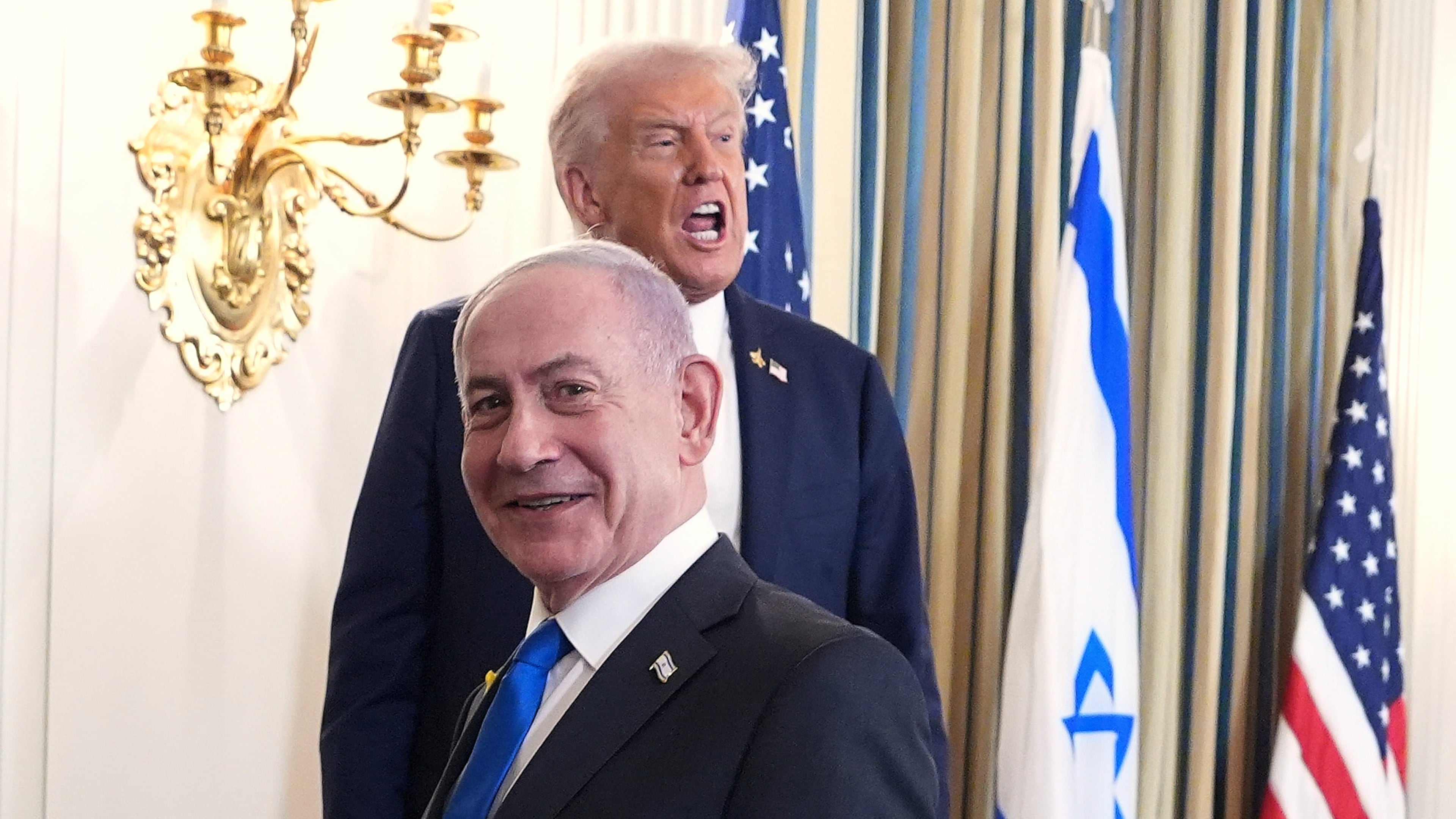 President Donald Trump speaks upon departing a news conference with Israeli Prime Minister Benjamin Netanyahu, in foreground, in the State Dining Room of the White House, Monday, Sept. 29, 2025, in Washington. (AP Photo/Evan Vucci)